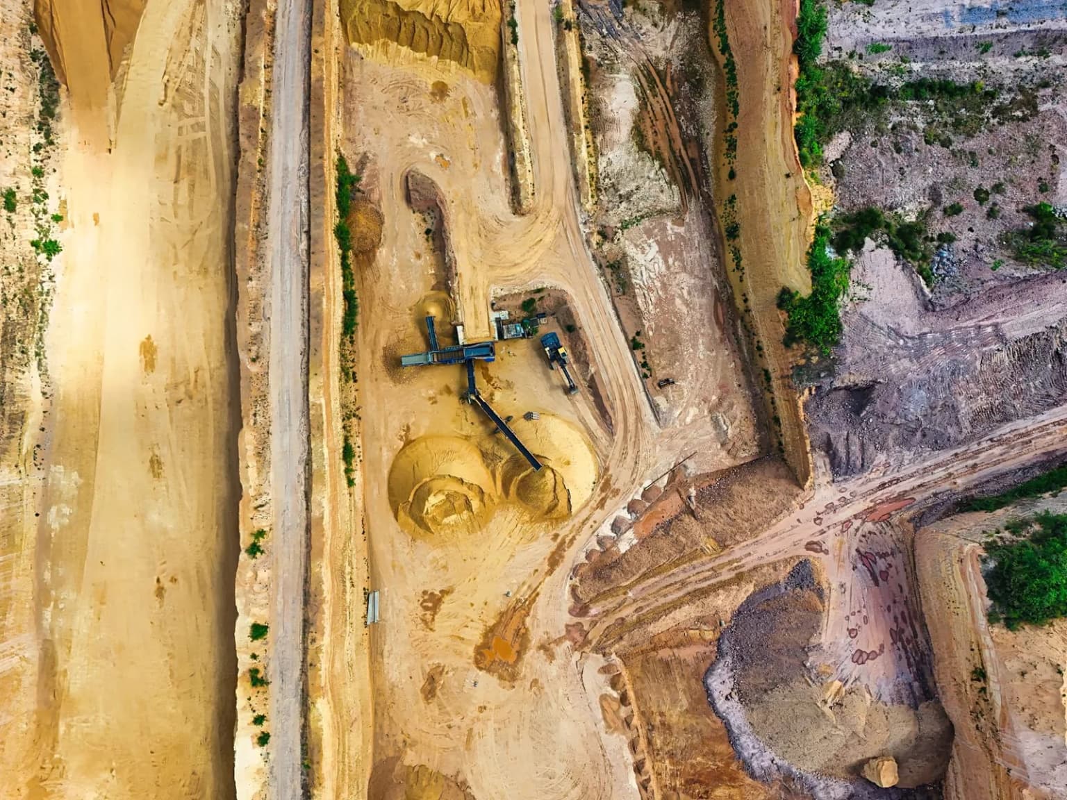 An aerial view of mineral extraction, with layered earth and machinery